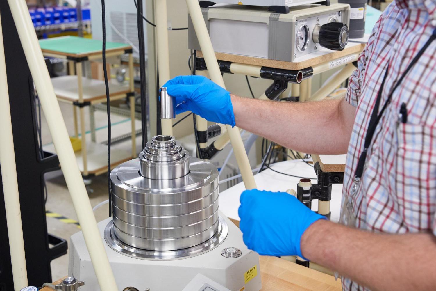 Maintenance professional calibrating the Fluke 7601 piston gauge. 